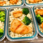 A perfectly cooked chicken, rice, and broccoli meal prep combination in meal prep containers.